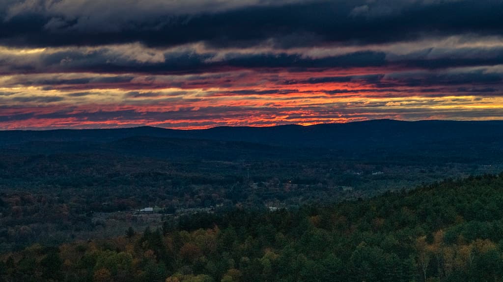 Sunrise over farm fields and hills in fall color